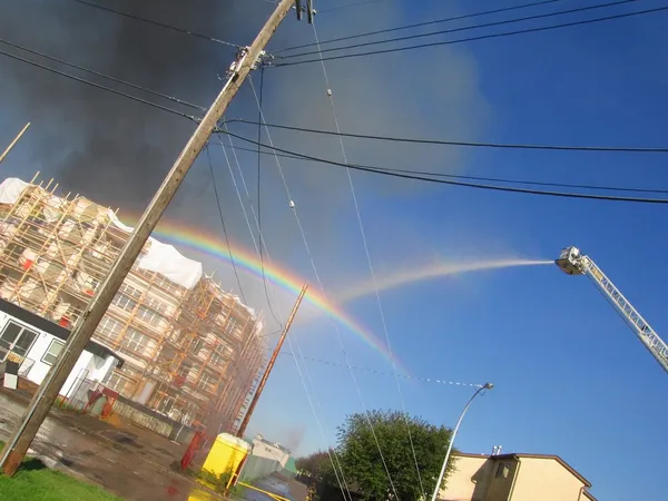 火の建物の近くの虹 — ストック写真