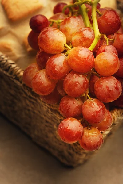 En närbild av röda druvor och en limpa bröd — Stockfoto