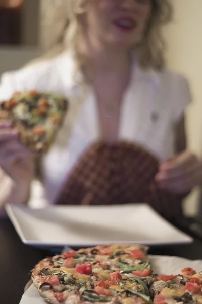 Kvinna äter pizza — Stockfoto
