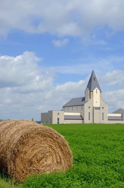Iglesia campestre con una bala de heno en primer plano — Foto de Stock