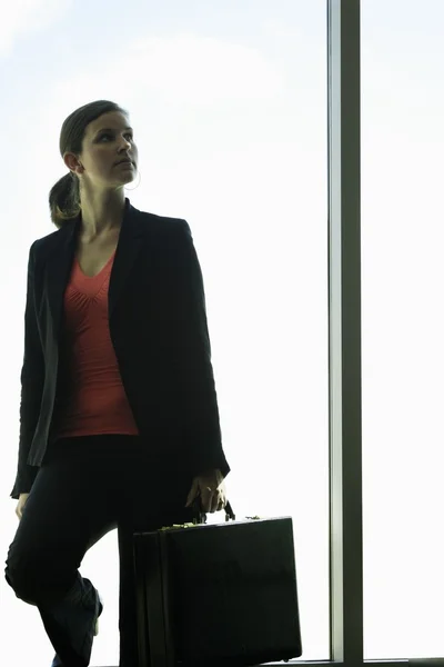 Una mujer de negocios delante de una ventana — Foto de Stock