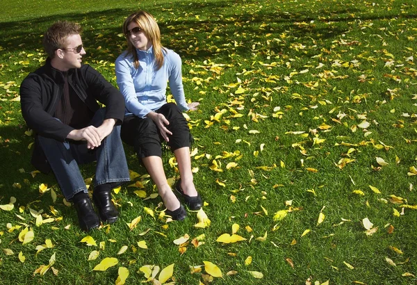 Couple assis sur l'herbe — Photo