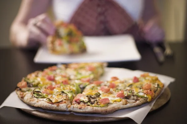 Vrouw eten pizza, vooraanzicht — Stockfoto