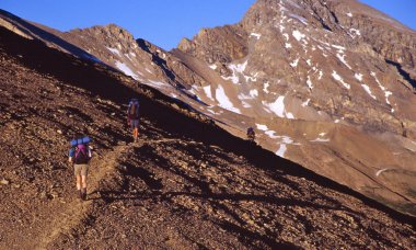 Beyaz Keçi vahşi bölgede katarakt çaprazlayan backpackers geçmek