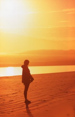 Silhouette Of Person Alone On Golden Beach clipart