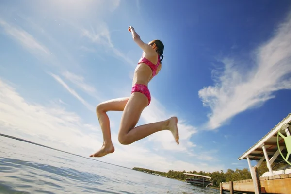 Une adolescente sautant dans un lac — Photo