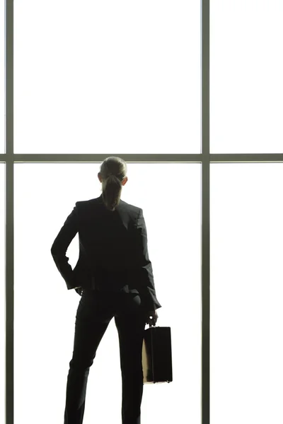 Mujer de negocios mirando por una ventana — Foto de Stock