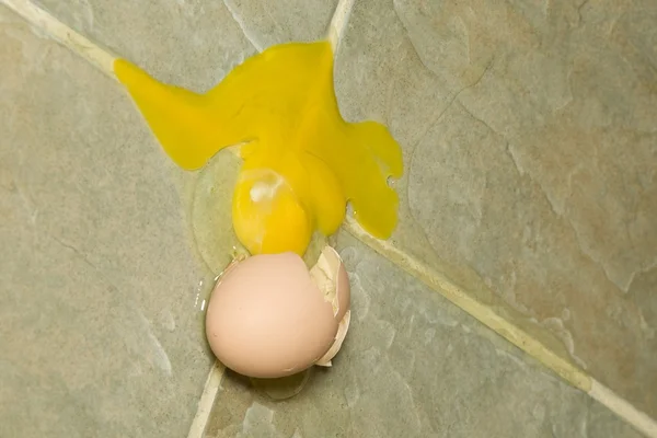 Risses Ei auf dem Fußboden — Stockfoto