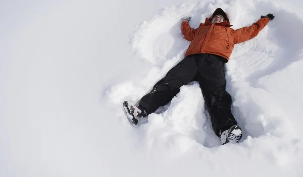 Jongen om sneeuw engel — Stockfoto
