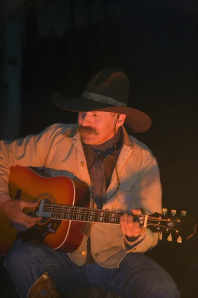 Cowboy spela gitarr vid lägerelden — Stockfoto