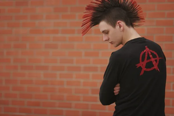 Молодой человек с ирокезом и символом анархии на одежде — стоковое фото