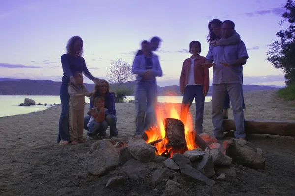 Eine Gruppe von Freunden und Familie am Lagerfeuer am Strand — Stockfoto