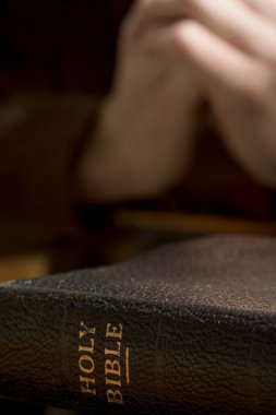 Closeup Of Bible With Praying Hands clipart