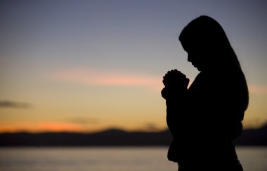 A Teenage Girl Prays At Sunset clipart