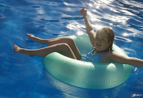 Junges Mädchen spielt im Wasser auf Röhre — Stockfoto