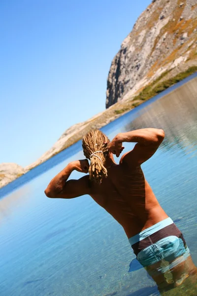 Adam dağ gölü içinde yüzmeye gidiyor — Stok fotoğraf