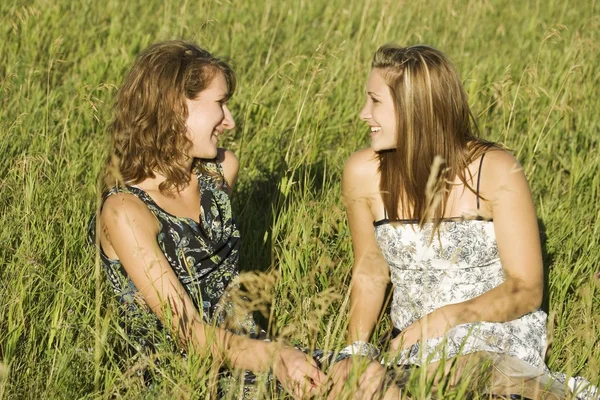 Zwei Frauen, die auf dem Feld sitzen und reden — Stockfoto