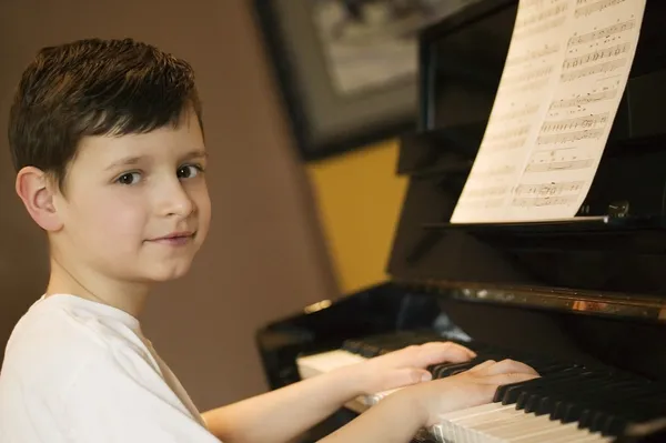 Mladý chlapec hrát na klavír — Stock fotografie