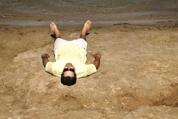 Hombre acostado en la playa — Foto de Stock