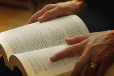 açık bir kitap tutan eller
