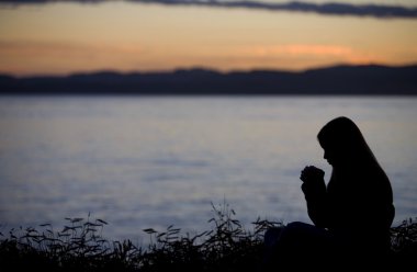 A Teenage Girl Praying Over Lake clipart