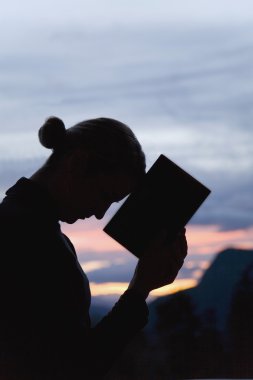 bir kitap olan kadın silüeti