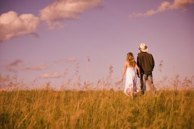 Man And Women Holding Hands And Walking In Field clipart