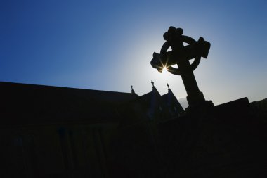 Silhouetted Celtic Cross And Church clipart