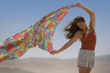 bir kadın bir eşarp Rüzgar dışarı tutar.