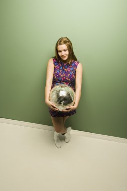 bir disko topu tutan kız gülümseyerek