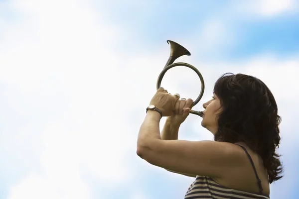 Vrouw spelen een hoorn — Stockfoto