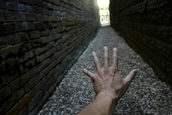 Mano que alcanza abajo Callejón estrecho hacia la luz — Foto de Stock