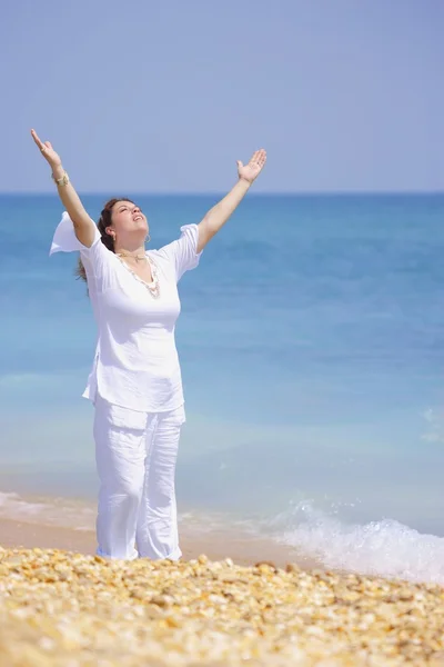 Kobieta podnosi jej ręce na plaży — Zdjęcie stockowe