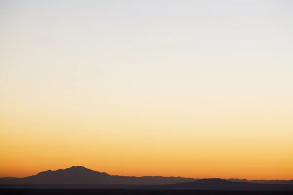Céu do pôr do sol sobre montanhas silhuetas — Fotografia de Stock