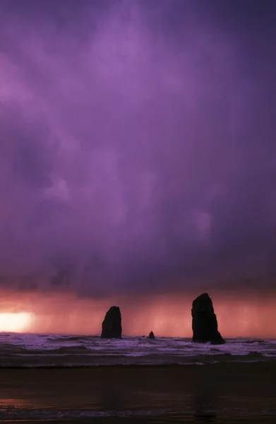 Puesta de sol sobre agujas en el océano en Cannon Beach —  Fotos de Stock