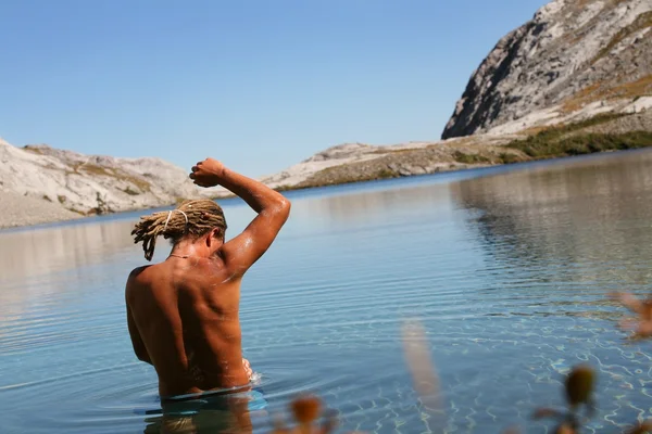 Mann badet im Bergsee — Stockfoto