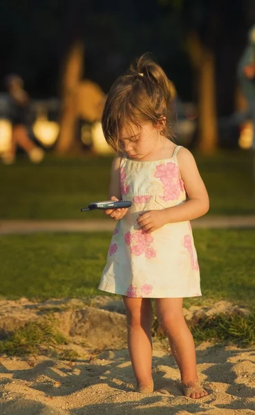 Ragazza che gioca con un cellulare — Foto Stock