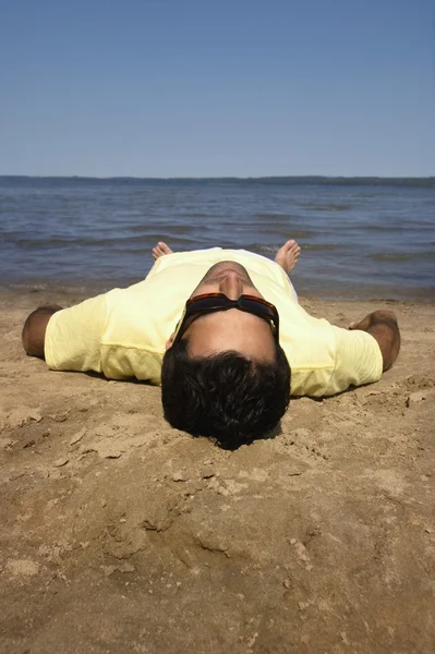 Homem deitado na praia — Fotografia de Stock