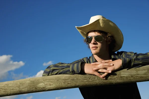 Jonge cowboy leunend op corral — Stockfoto