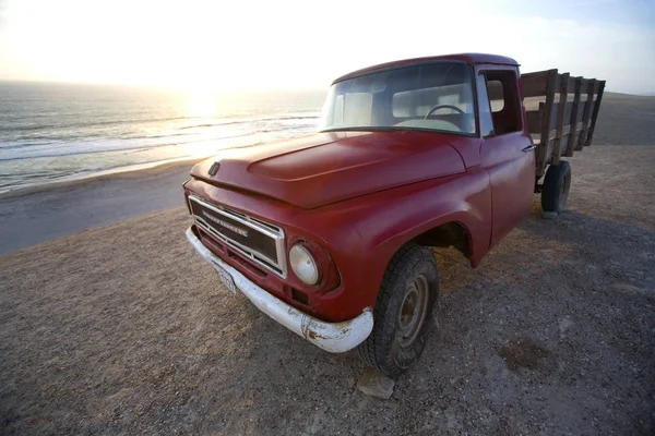 Camion agricole rouge sur la plage — Photo