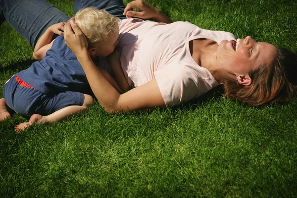 Mãe e filho brincando na grama — Fotografia de Stock