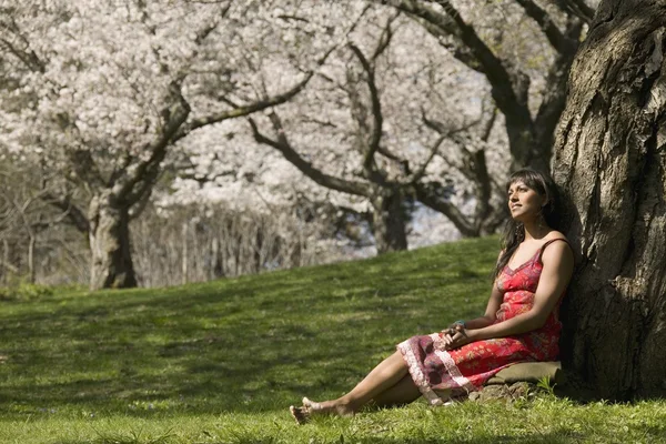 Vrouw ontspannen onder kersenboom blossoms — Stockfoto