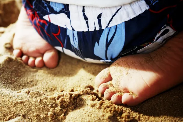 Kind sitzt im Sand — Stockfoto