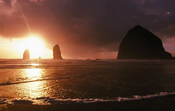 Zonsondergang op hooiberg rots in cannon beach — Stockfoto