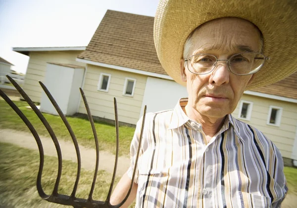 Agricultor sosteniendo una horquilla —  Fotos de Stock