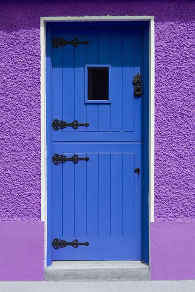 Lila vägg blå dörren — Stockfoto