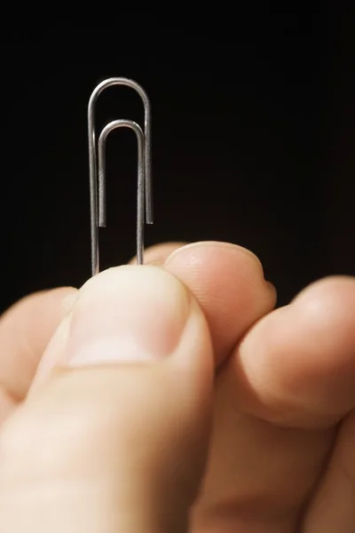 Persoon die houder is van een paperclip — Stockfoto