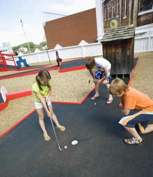 Niños jugando mini golf — Foto de Stock