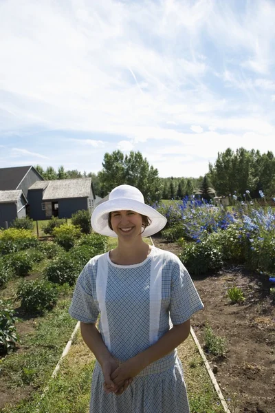 Frau in altmodischer Kleidung steht im Garten — Stockfoto