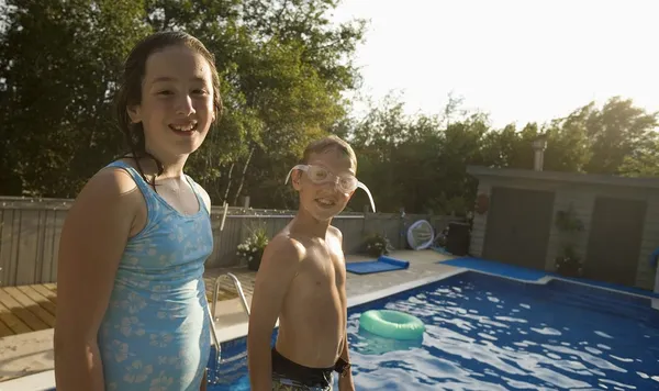 Lány és fiú mosolyogva medence — Stock Fotó